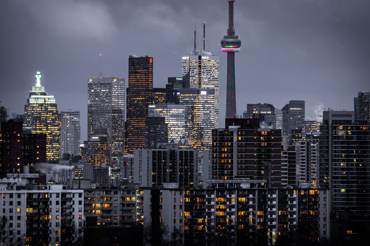 Apartment buildings and high-rises lit at dusk against a city skyline